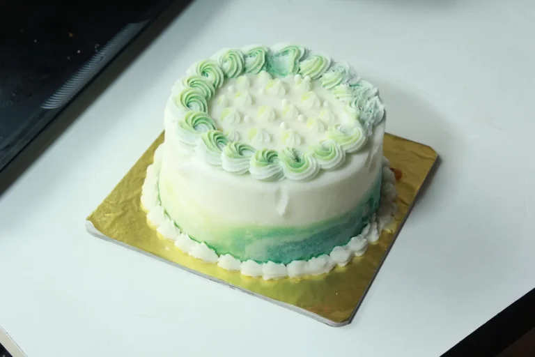Pastel birthday cake with piped cream